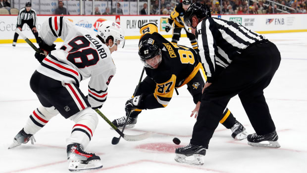 Connor Bedard and Sidney Crosby line up for a faceoff